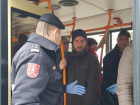 Полицейские контролируют, чтобы люди не подходили близко друг к другу в троллейбусах