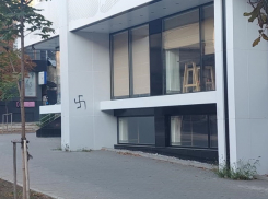 Некий кишиневский коммерсант смакует свастику на стене своего магазина