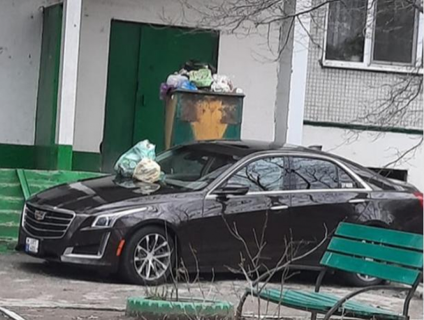 На небрежно припаркованный перед 9-этажкой советской постройки шикарный Cadillac высыпали кучу мусора