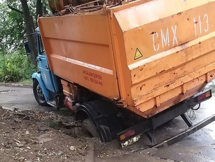 То яма, то канава - грузовой спецтранспорт провалился в Кишиневе на ровном месте
