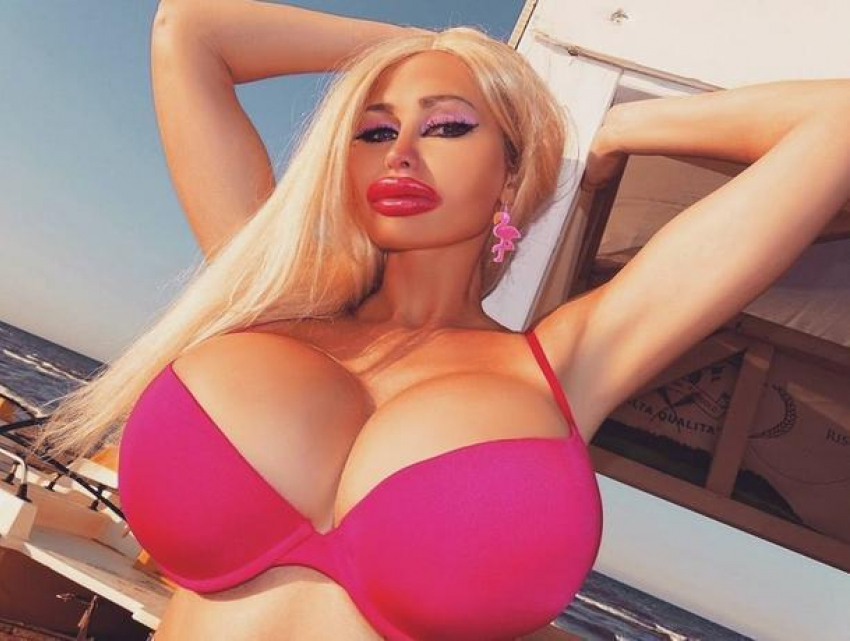 Блондинка с большой грудью в розовом купальнике держится за край бассейна | Премиум Фото